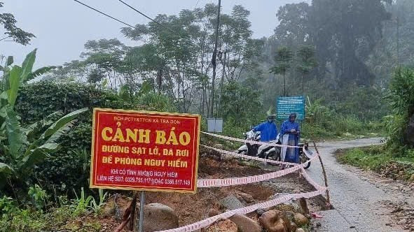 Lực lượng chức năng cắm biển cảnh báo nguy cơ sạt lở trên tuyến đường vào xã Trà Don, huyện Nam Trà My