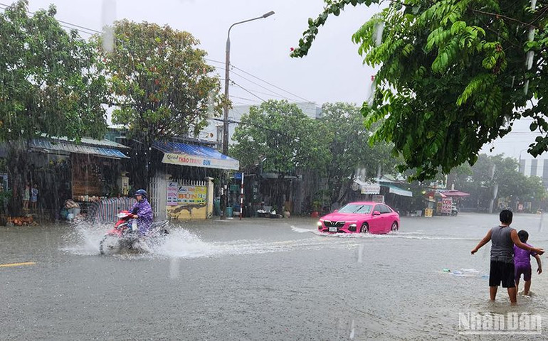 Mưa to kéo dài làm đường Lý Thường Kiệt, thành phố Tam Kỳ bị ngập nước, các phương tiện lưu thông gặp khó khăn.