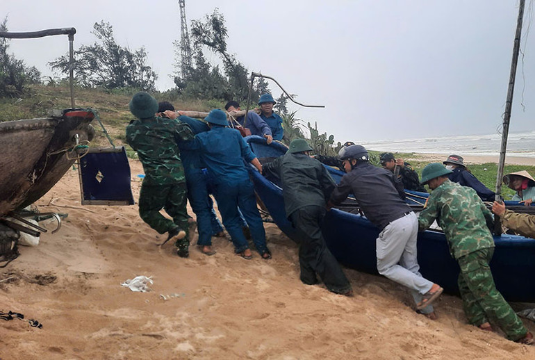 Các lực lượng vũ trang huyện Thăng Bình khẩn trương giúp ngư dân đưa tàu thuyền vào bờ an toàn.