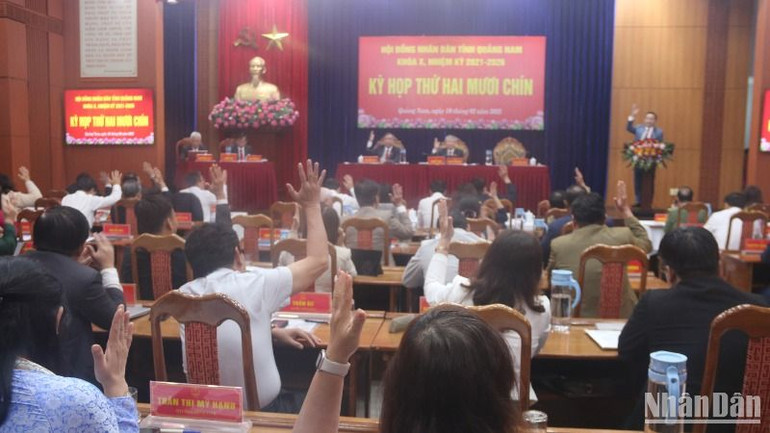 Các đại biểu Hội đồng nhân dân tỉnh biểu quyết thông qua nghị quyết phê chuẩn cơ cấu các cơ quan chuyên môn thuộc Ủy ban nhân dân tỉnh Quảng Nam.