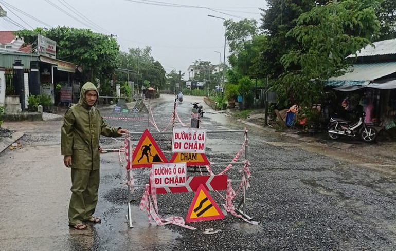 Cắm biển cảnh báo các phương tiện tham gia giao thông qua lại các tuyến đường ngập nước, hư hỏng tại huyện Duy Xuyên.