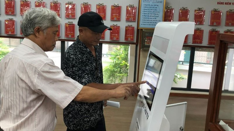 Người dân lấy số thứ tự làm thủ tục hành chính tại bộ phận "một cửa" Ủy ban nhân dân quận Hai Bà Trưng.