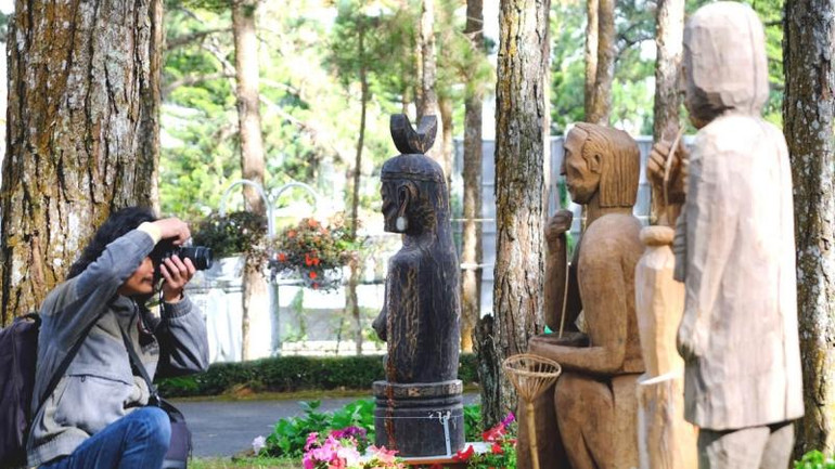 Tượng gỗ Tây Nguyên và hoa Đà Lạt giữa không gian rừng thông. Tượng gỗ Tây Nguyên và hoa Đà Lạt giữa không gian rừng thông.