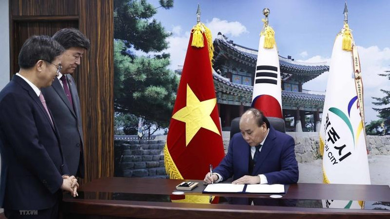 Chủ tịch nước Nguyễn Xuân Phúc ký sổ vàng lưu niệm tại Văn phòng Tỉnh trưởng tỉnh Gyeonggi. (Ảnh: Thống Nhất/TTXVN)