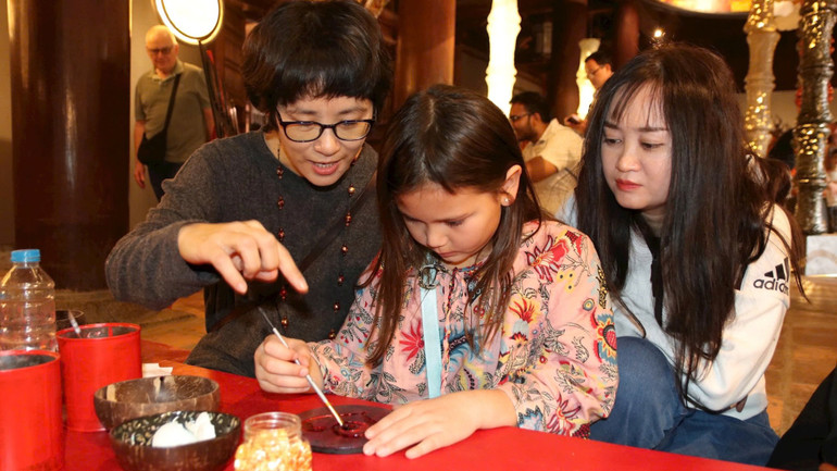 Các nghệ sĩ cùng khách tham quan làm tác phẩm sơn mài tại Văn Miếu-Quốc Tử Giám. Các nghệ sĩ cùng khách tham quan làm tác phẩm sơn mài tại Văn Miếu-Quốc Tử Giám.