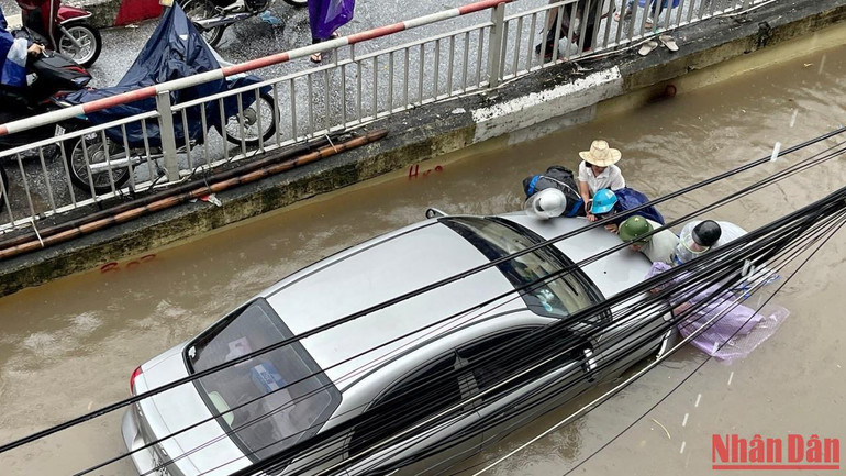 Người dân đi đường giúp chủ phương tiện ô-tô đẩy xe lên phần đường cao hơn. Người dân đi đường giúp chủ phương tiện ô-tô đẩy xe lên phần đường cao hơn.