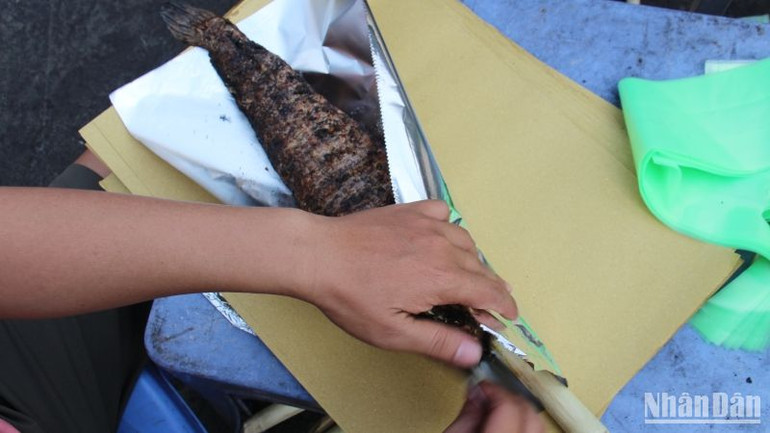 Cá lóc nướng được người bán gói cẩn thận bằng giấy bạc.