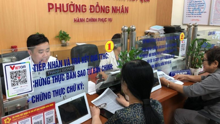 Cán bộ Ủy ban nhân dân phường Đồng Nhân (quận Hai Bà Trưng) phục vụ người dân làm thủ tục hành chính.