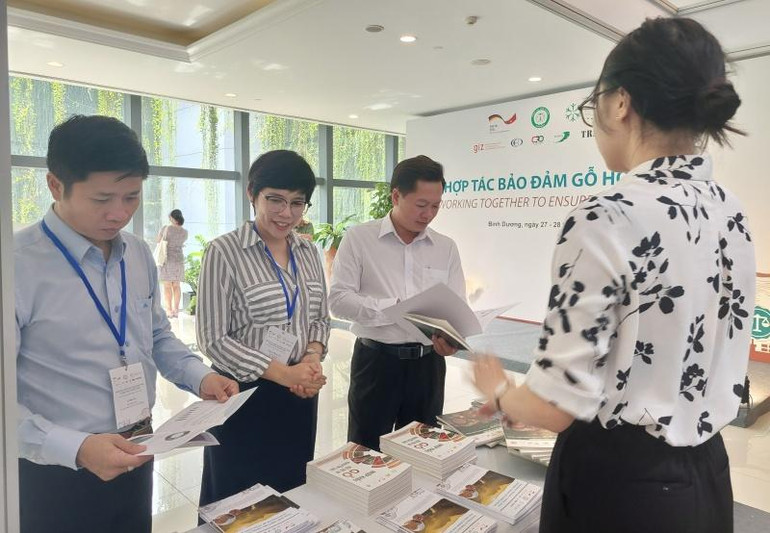 Các đại biểu tham quan trưng bày ấn phẩm truyền thông nhằm kết nối và trao đổi thông tin về thúc đẩy chuỗi giá trị gỗ hợp pháp và bền vững.