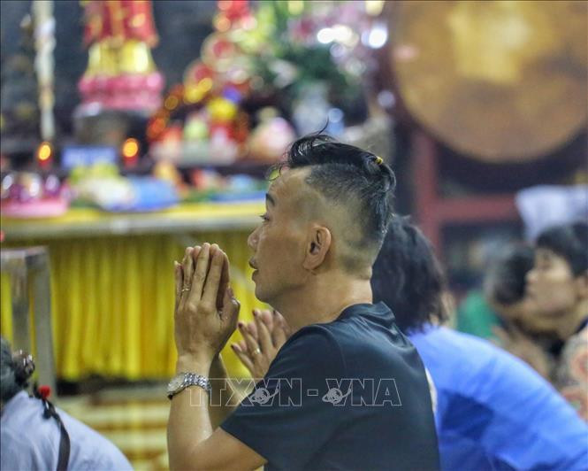 Người dân thành tâm cầu khấn tại chùa Quán Sứ dù trời mưa to.