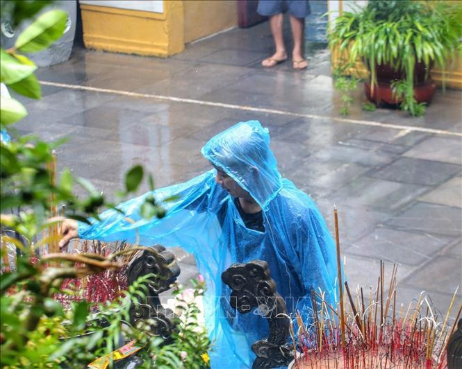 Đội mưa đến chùa Quán Sứ thắp nén tâm hương.