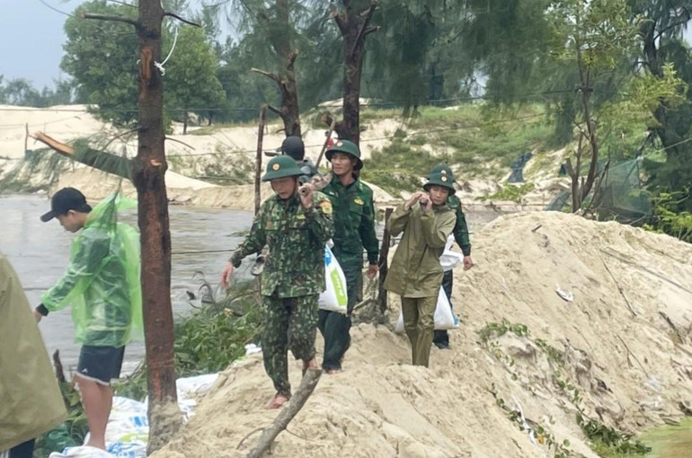 Bộ đội Biên phòng hỗ trợ người dân Ngư Thủy bị gia cố bờ bao, tránh bị thiệt hại trong nuôi thủy sản.