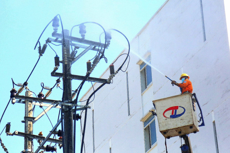 Công nhân điện lực Đà Nẵng vệ sinh lưới điện bằng nước áp lực cao.