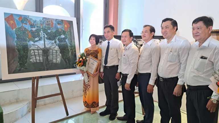 Các đại biểu chụp hình lưu niệm với tác giả Phạm Thị Hồng Xuyến có tác phẩm “Cuộc chiến không tiếng súng” đoạt giải Nhì cuộc thi.