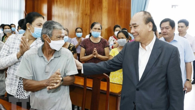 Chủ tịch nước Nguyễn Xuân Phúc hỏi thăm hộ nghèo, công nhân lao động có hoàn cảnh khó khăn, người nhiễm chất độc da cam tại huyện Châu Thành. (Ảnh: Thống Nhất/TTXVN)