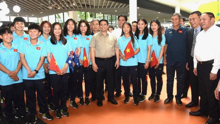 Thủ tướng Phạm Minh Chính với ban huấn luyện và các cầu thủ đội bóng đá nữ Việt Nam.