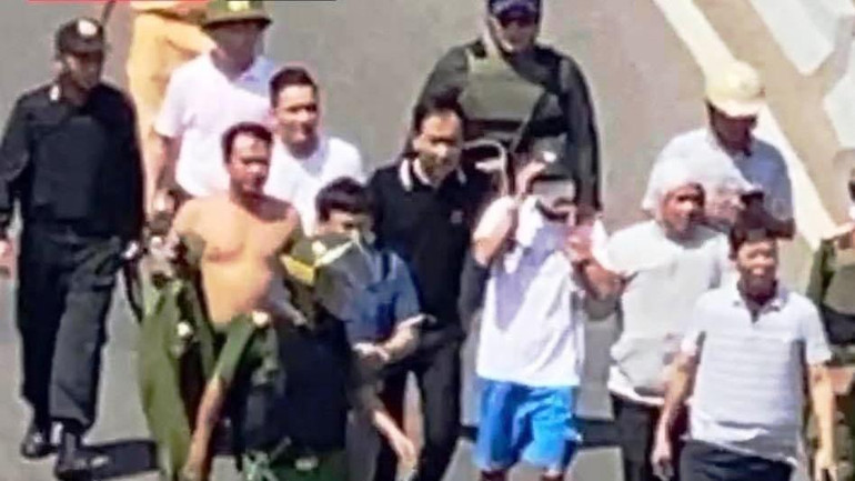 Các lực lượng chức năng vây bắt đối tượng (quần đùi xanh, áo trắng) sau khi đối tượng đồng ý buông súng đầu thú và giao nộp vũ khí.