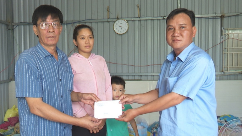 Phó Chủ tịch Ủy ban nhân dân xã Tân Phú Đông Lê Văn Giàu đến trao tiền hỗ trợ cho gia đình có nhà bị sụp xuống sông.