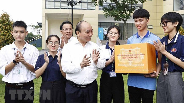 Chủ tịch nước Nguyễn Xuân Phúc tặng quà cho sinh viên Đại học Quốc gia Thành phố Hồ Chí Minh. (Ảnh: Thống Nhất/TTXVN)