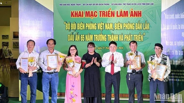 Phó Bí thư Thường trực Tỉnh ủy Đắk Lắk Phạm Minh Tấn và Chủ tịch Hội Văn học nghệ thuật tỉnh Đắk Lắk nhà văn Niê Thanh Mai trao giấy chứng nhận cho các tác giả có ảnh được trưng bày tại triển lãm.