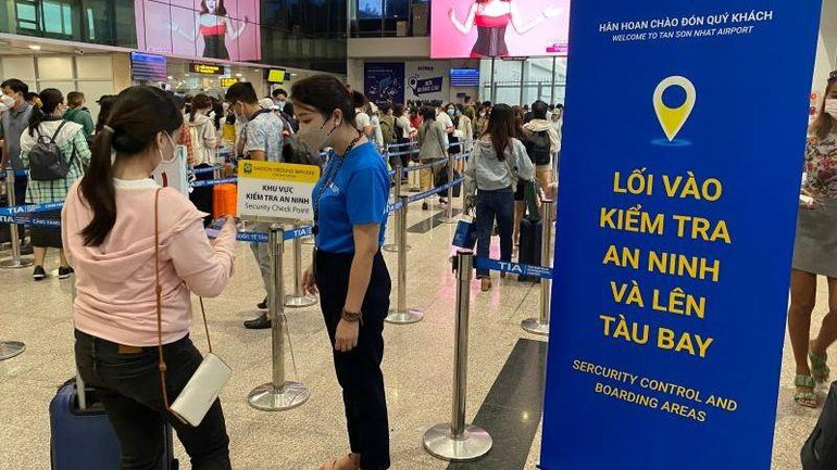 Sân bay Tân Sơn Nhất bố trí đội ngũ nhân viên kèm biển thông báo hướng dẫn hành khách làm thủ tục bay và di chuyển thuận tiện.