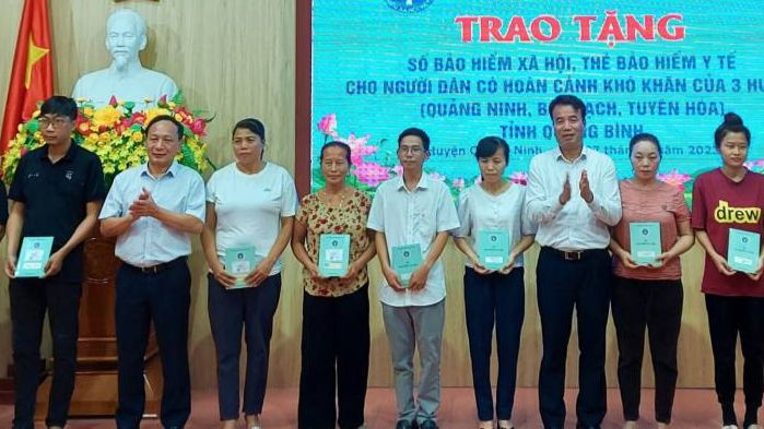 Các đại biểu trao tặng sổ bảo hiểm xã hội, thẻ bảo hiểm y tế cho người có hoàn cảnh khó khăn.