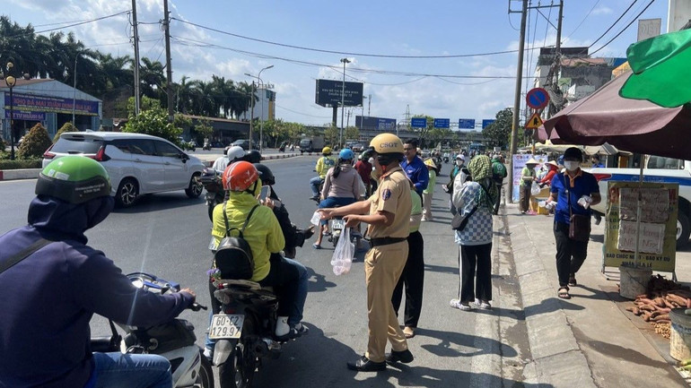Cảnh sát giao thông phát nước suối cho người dân trên đường về quê nghỉ lễ.