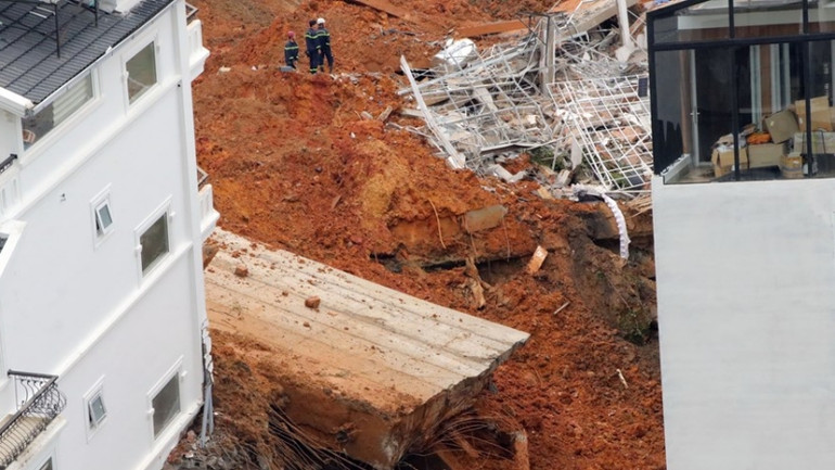 Bờ kè bê-tông cao hàng chục mét bị gãy dẫn đến sạt lở nghiêm trọng. (Ảnh: Chu Quốc Hùng/TTXVN)