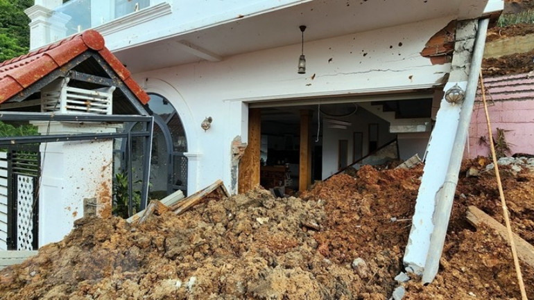 Một căn nhà bị đất đá vùi lấp tầng 1. (Ảnh: Chu Quốc Hùng/TTXVN)