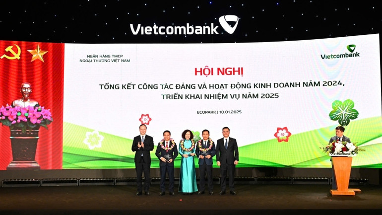 Ban lãnh đạo Vietcombank trao biểu trưng và tặng hoa vinh danh cho đại diện 3 Đơn vị đặc biệt xuất sắc trong năm 2024: Chi nhánh Sở Giao dịch (thứ 4 từ trái sang), Chi nhánh Thành Công (thứ 3 từ trái sang) và Chi nhánh Nam Sài Gòn (thứ 2 từ trái sang). Ban lãnh đạo Vietcombank trao biểu trưng và tặng hoa vinh danh cho đại diện 3 Đơn vị đặc biệt xuất sắc trong năm 2024: Chi nhánh Sở Giao dịch (thứ 4 từ trái sang), Chi nhánh Thành Công (thứ 3 từ trái sang) và Chi nhánh Nam Sài Gòn (thứ 2 từ trái sang).
