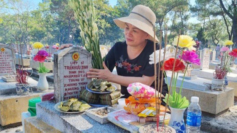 Con gái thắp hương cho bố đang yên nghỉ tại Nghĩa trang liệt sĩ Trường Sơn.