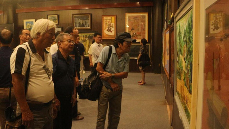 Các khán giả tham quan trưng bày các tác phẩm mỹ thuật tại triển lãm.