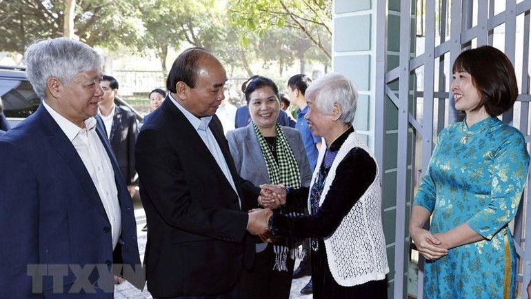 Chủ tịch nước Nguyễn Xuân Phúc thăm bà Đinh Thị Huệ, vợ liệt sĩ ở tổ dân phố số 5, phường Tân Phong, thành phố Lai Châu.