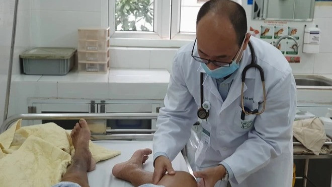 Phó Giáo sư, Tiến sĩ Đỗ Duy Cường khám cho bệnh nhân mắc Whitmore đang điều trị. (Ảnh: PV/Vietnam+)