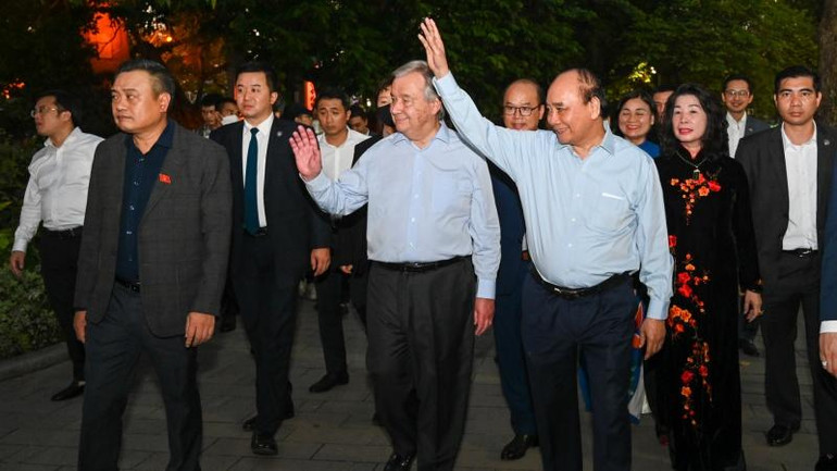 Chủ tịch nước Nguyễn Xuân Phúc và Tổng Thư ký Liên hợp quốc António Guterres vẫy tay chào người dân Hà Nội tại khu vực tuyến phố đi bộ Hồ Hoàn Kiếm.