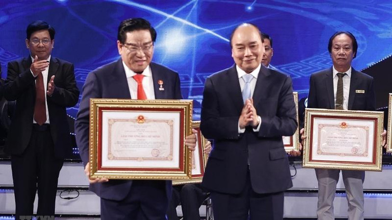 Chủ tịch nước Nguyễn Xuân Phúc trao Giải thưởng Hồ Chí Minh cho tác giả, đại diện tác giả, đại diện đồng tác giả của 12 công trình, cụm công trình được tặng Giải thưởng Hồ Chí Minh. (Ảnh: Thống Nhất/TTXVN)