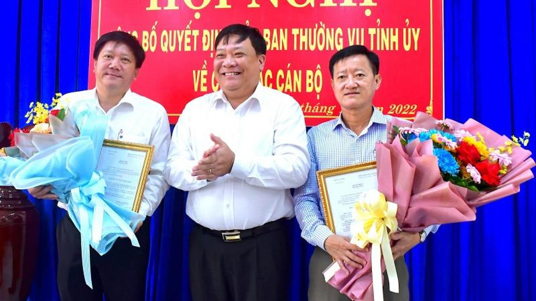 Phó Bí thư Thường trực Tỉnh ủy Cà Mau (giữa) trao Quyết định và hoa chúc mừng đồng chí Phạm Việt Phong, Nguyễn Thanh Toản được giao nhiệm vụ mới.