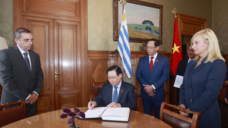 Chủ tịch Quốc hội Vương Đình Huệ ký sổ lưu niệm. (Ảnh: Doãn Tấn/TTXVN)