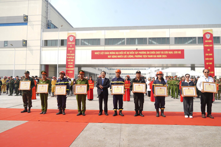 Đồng chí Nguyễn Đức Vượng, Phó Chủ tịch UBND tỉnh tặng Bằng khen của Chủ tịch UBND tỉnh cho các tập thể, cá nhân tiêu biểu trong tham mưu, triển khai thực hiện diễn tập. (Ảnh: Nguyễn Khánh)