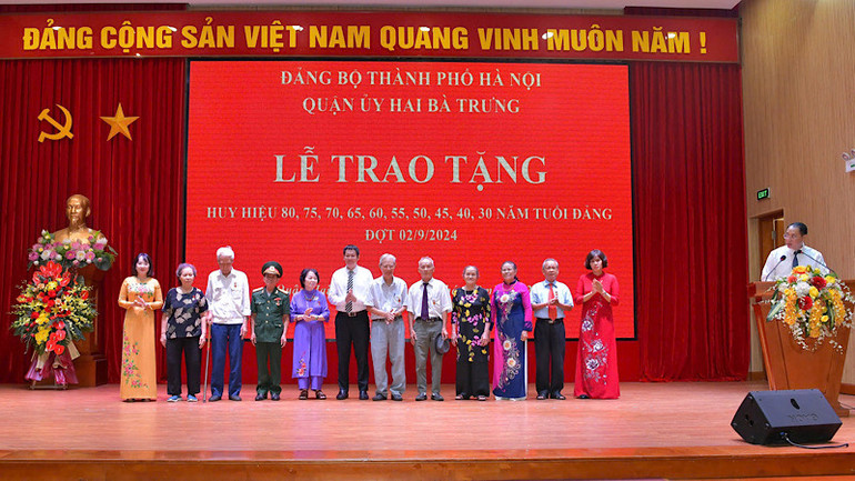 Đại diện Quận ủy trao tặng Huy hiệu 55 năm tuổi Đảng cho các đảng viên.