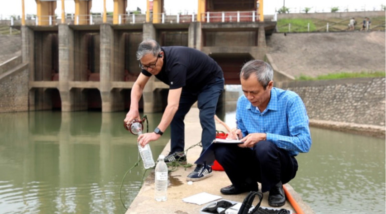 Cán bộ Viện nước Tưới tiêu và Môi trường lấy mẫu kiểm tra chất lượng nước tại trạm bơm dã chiến Xuân Quan.