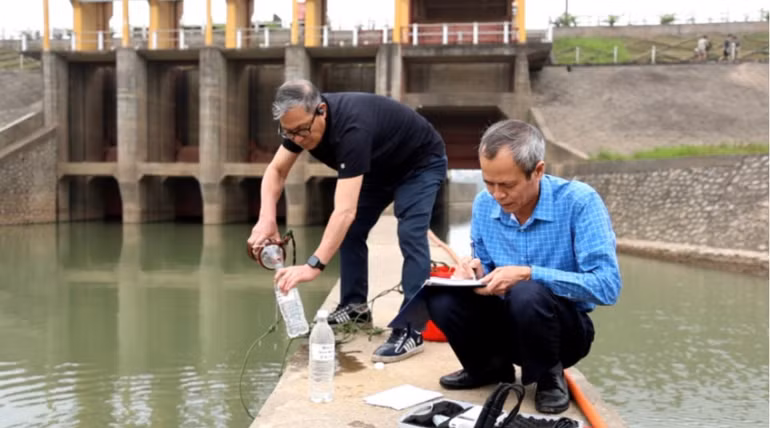 Cán bộ Viện nước Tưới tiêu và Môi trường lấy mẫu kiểm tra chất lượng nước tại trạm bơm dã chiến Xuân Quan.