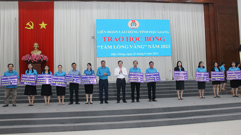 Trao bảng tượng trưng phân bổ số học bổng cho các đơn vị cấp huyện.