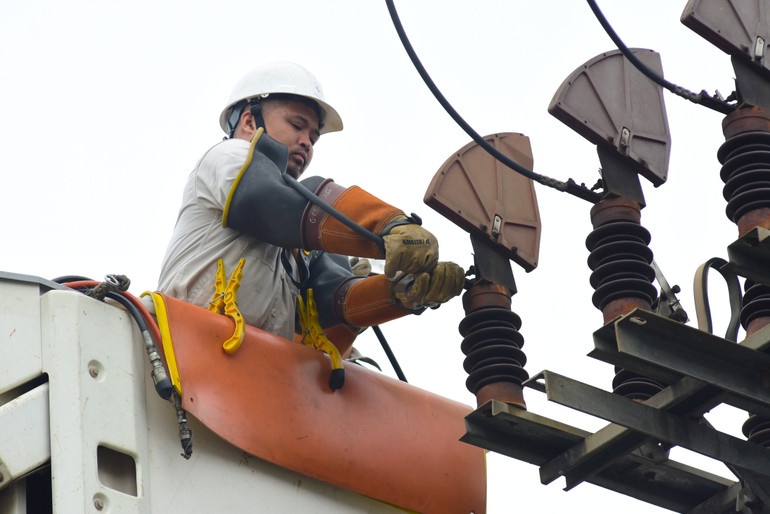 Đội hotline làm việc trên lưới điện mang tải 22kV. (Ảnh: EVNHANOI)