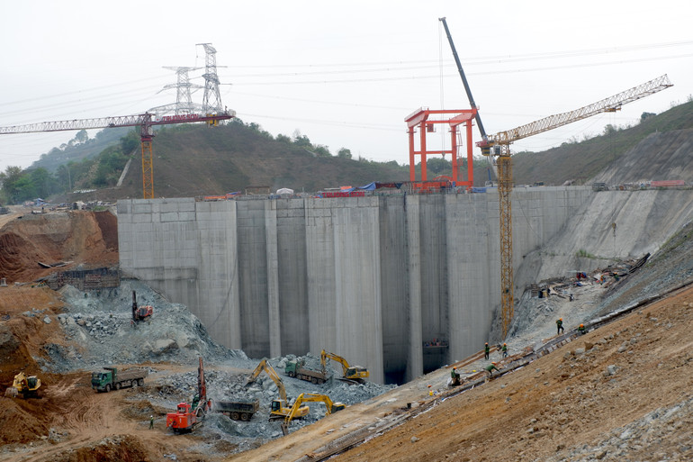 Trên công trường, khu vực đê quây hiện đang được tập trung cao độ, huy động phương tiện, trang thiết bị để di dời đất, đá khỏi vị trí. Hạng mục tháo dỡ đê quây, thi công kênh dẫn vào cửa lấy nước giai đoạn 3 này, phụ thuộc hoàn toàn vào việc vận hành khai thác hỗ trợ điều tiết hạ mực nước hồ Thủy điện Hòa Bình. (Ảnh: LÊ CHI)