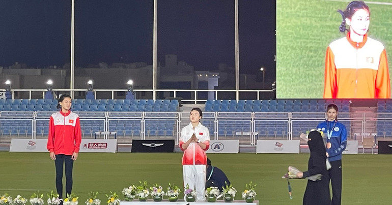 Mai Ngọc Ánh (bên trái, áo đỏ) trên bục nhận Huy chương.