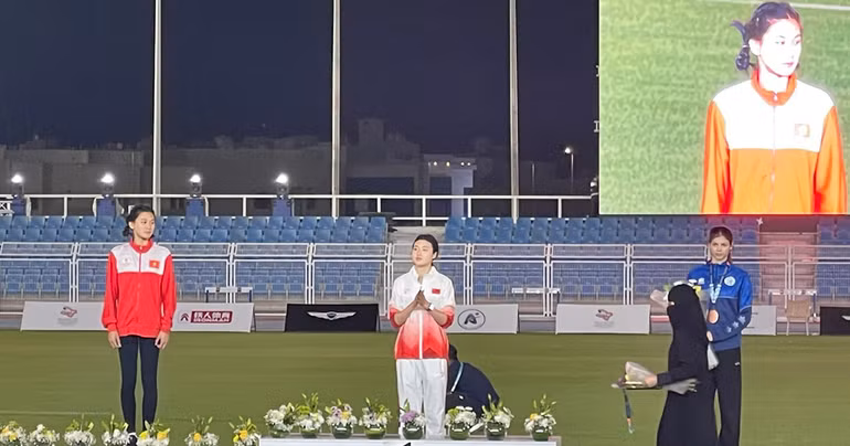 Mai Ngọc Ánh (bên trái, áo đỏ) trên bục nhận Huy chương.