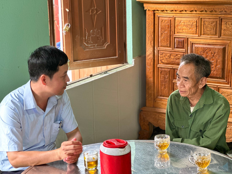 Chủ tịch xã Trà Leng Phan Quốc Cường (trái) đến thăm hỏi ông Hồ Văn Đề.