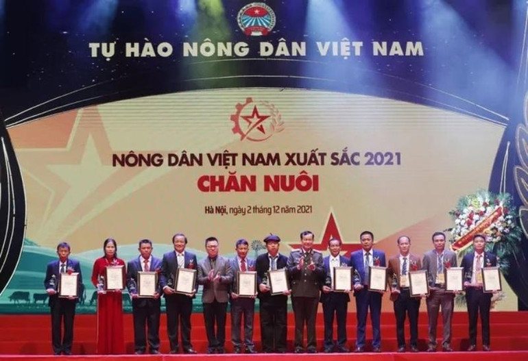 Đồng chí Lê Tấn Tới và đồng chí Lê Quốc Minh trao danh hiệu Nông dân Việt Nam xuất sắc cho nhóm nông dân trong lĩnh vực chăn nuôi. (Ảnh: danviet.vn) Lễ tôn vinh và trao danh hiệu cho 63 “Nông dân Việt Nam xuất sắc 2021” -0