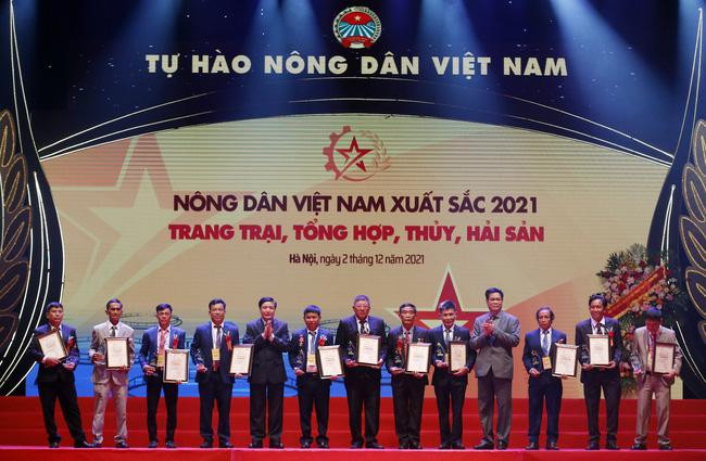 Đồng chí Bùi Văn Cường và đồng chí Huỳnh Tấn Việt trao danh hiệu Nông dân Việt Nam xuất sắc cho nhóm nông dân ở lĩnh vực trang trại tổng hợp và thủy hải sản. (Ảnh: danviet.vn) Lễ tôn vinh và trao danh hiệu cho 63 “Nông dân Việt Nam xuất sắc 2021” -0